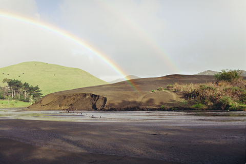 Aussicht auf doppelte Regenbögen über Fluss und Berge, lizenzfreies Stockfoto