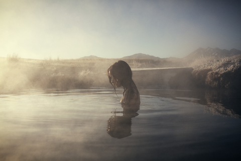 Seitenansicht einer Frau beim Schwimmen in den Mammoth Lake Hot Springs, lizenzfreies Stockfoto