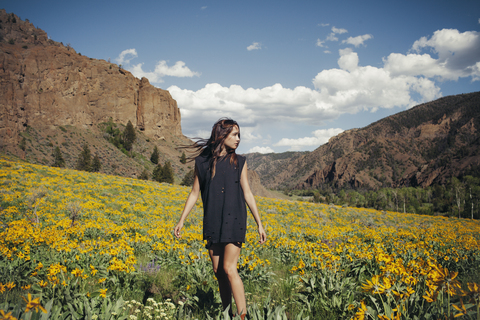 Front view of woman standing on field against mountains stock photo