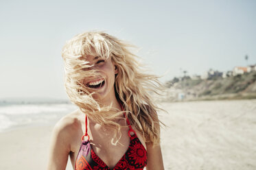Porträt einer fröhlichen Frau am Strand - CAVF16752