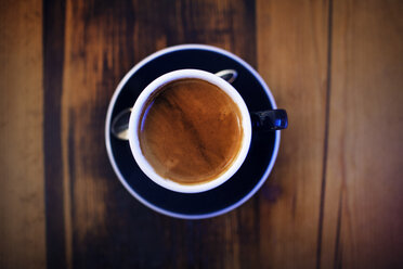 Overhead view of coffee cup on wooden table - CAVF16781