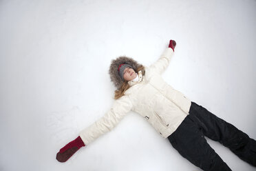 High angle view of woman lying on snow field - CAVF16801