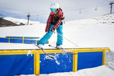 Frau vollführt Stunt beim Skifahren auf dem Geländer - CAVF16828