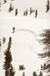 Hoher Blickwinkel auf einen Mann mit Rucksack auf einem schneebedeckten Feld - CAVF16844