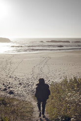 Rear view of woman walking on steps leading towards beach - CAVF16885