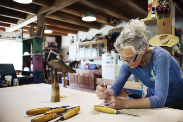 Konzentrierte Frau mit Meißel zum Formen von Holz in der Werkstatt - CAVF16912