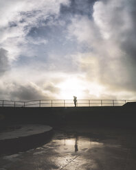 Silhouette Frau stehend am Geländer gegen bewölkten Himmel bei Sonnenuntergang - CAVF16923