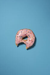Overhead-Ansicht von Donut gegessen Biss auf blauem Hintergrund - CAVF16934