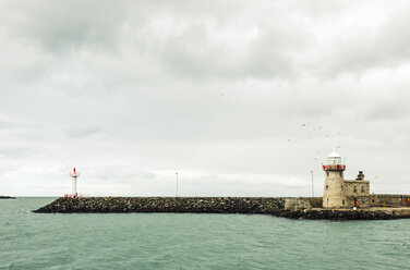 Lighthouse by sea against cloudy sky - CAVF16939