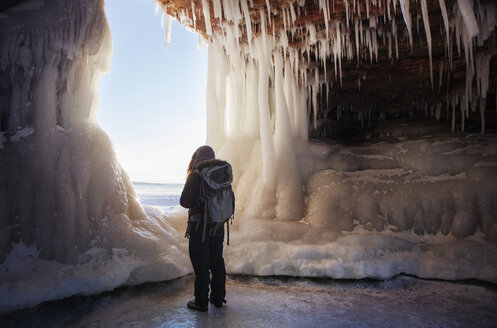 Rear view of woman standing in ice cave - CAVF16984