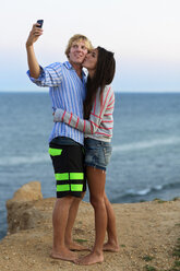 Paar nimmt Selfie im Stehen gegen das Meer - CAVF17077