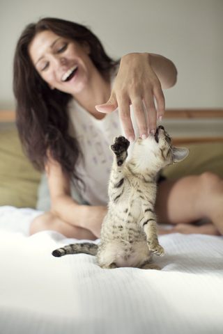 Glückliche Frau spielt mit Katze zu Hause, lizenzfreies Stockfoto