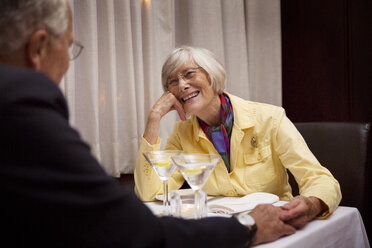 Ältere Frau sieht Mann an, während sie im Restaurant sitzt - CAVF17183