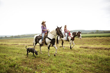 Freundinnen reiten auf Pferd gegen Himmel - CAVF17203