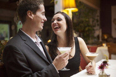 Glückliches Paar mit Cocktail in der Hand in einem Restaurant - CAVF17226