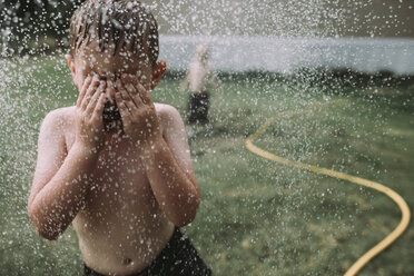 Brothers playing in sPRinkler at yard - CAVF17243