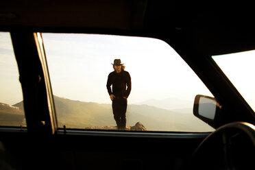 Man walking on mountain seen through car window - CAVF17251