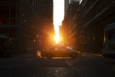 Vehicles on street amidst buildings during sunset - CAVF17272