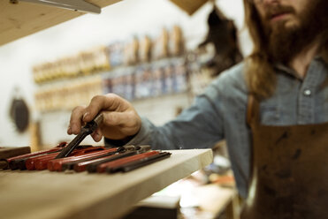 Beschnittenes Bild eines Schuhmachers bei der Arbeit in einer Werkstatt - CAVF17357