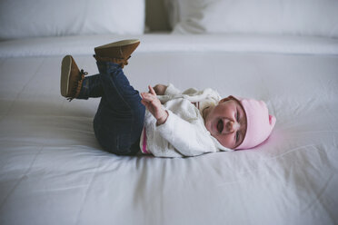 Fröhliches Baby, das lachend auf dem Bett zu Hause liegt - CAVF17431