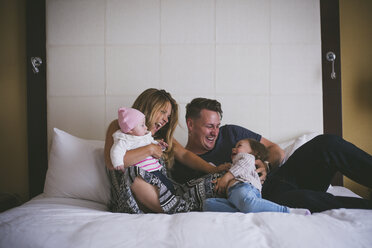 Happy family enjoying on bed at home - CAVF17434