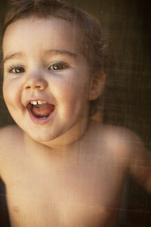 Baby girl looking through window - CAVF17546