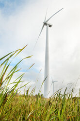 Low angle view of windmill on field against cloudy sky - CAVF17598