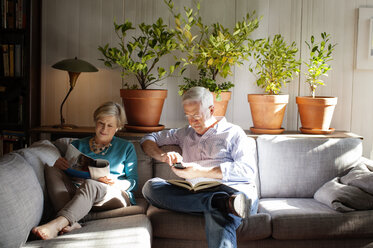 Senior couple sitting on sofa at home - CAVF17621