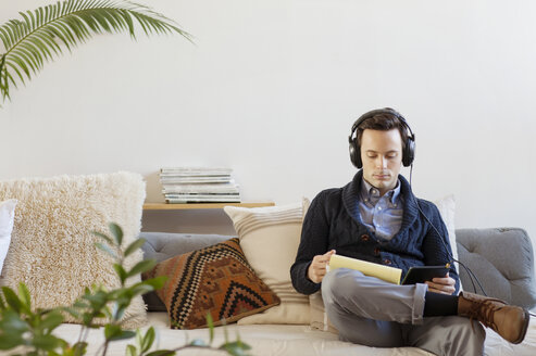 Geschäftsmann hört Musik bei der Arbeit im Büro - CAVF17633