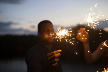 Friends holding sparklers at night - CAVF17663