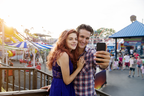 Junges Paar macht Selfie im Vergnügungspark, lizenzfreies Stockfoto