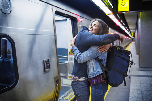 Verliebtes Paar, das sich umarmt, während es an einer U-Bahn-Station im Zug steht - CAVF17739