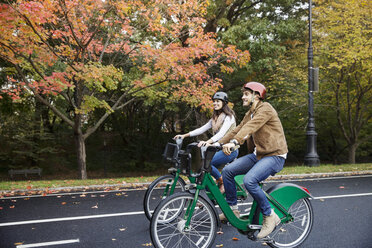 Lächelndes Paar beim Fahrradfahren im Park - CAVF17756