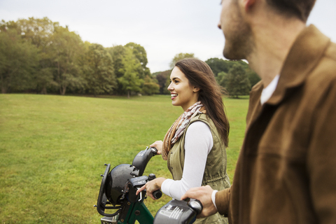 Glückliches Paar mit Fahrrädern im Park, lizenzfreies Stockfoto