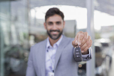 Portrait smiling, confident car salesman holding, showing new car keys - CAIF20087