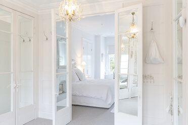 Weißes, luxuriöses Schlafzimmer mit französischen Türen und Kronleuchter - CAIF20140