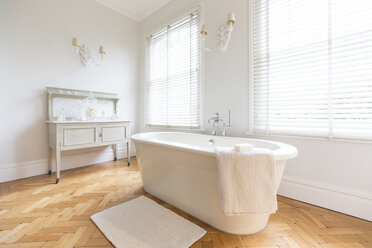 Weißes, luxuriöses Wohnhaus: Badezimmer mit Badewanne und Parkettboden - CAIF20142