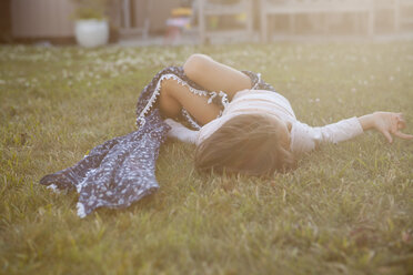 Serene girl laying in summer grass - CAIF20193