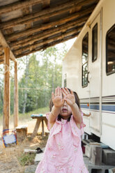 Porträt schüchternes Mädchen versteckt Gesicht mit Händen außerhalb der ländlichen Wohnmobil - CAIF20205