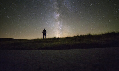 Mann stehend vor Sternenfeld bei Nacht - CAVF17859