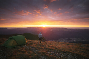 Rückansicht eines auf einem Berg stehenden Mannes bei Sonnenuntergang - CAVF17861