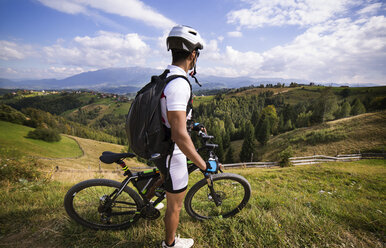 Side view of athlete with bicycle on mountain - CAVF17867