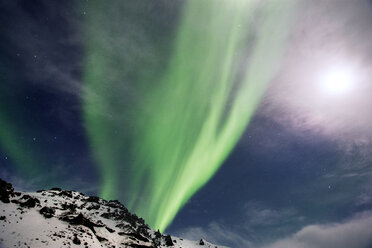 Low angle view of aurora borealis over snowcapped mountain at dusk - CAVF17999