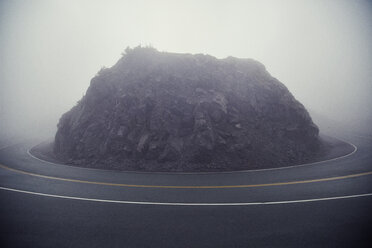 Felsformation inmitten der Landstraße bei nebligem Wetter - CAVF18067