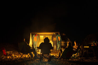 Freunde beim Zelten und Entspannen auf einem Stuhl am Strand - CAVF18075