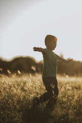 Full length of boy playing on grassy field - CAVF18136