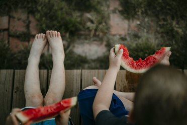 Overhead view of brothers eating watermelon while sitting at porch - CAVF18160