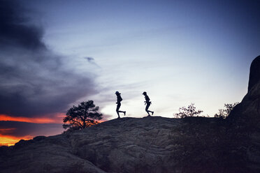 Silhouette Paar läuft auf dem Hügel gegen den Himmel bei Sonnenuntergang - CAVF18251