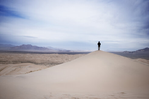 Mann steht auf einer Sanddüne in der Wüste - CAVF18262