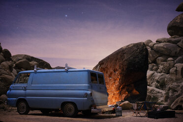 Van parked at campsite next to fire at dusk in Joshua Tree State Park - CAVF18265